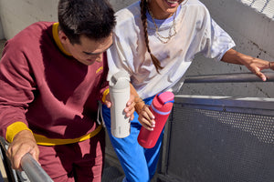 A guy and a girl holding Owala water bottles